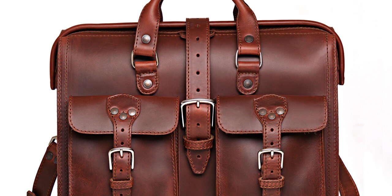What are the key materials used in manufacturing leather briefcases, portfolios, and laptop bags?